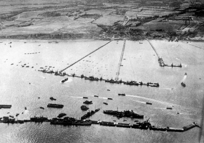 Shown deployed along a Normandy invasion beach, this Mullberry artificial harbor allowed supplies and reinforcements to be offloaded in support of the Allied landings which took place on June 6, 1944. This aerial view provides a perspective of the massive structure.