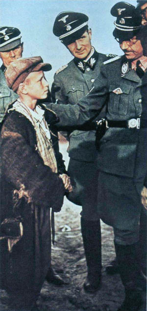 Reichsführer SS Heinrich Himmler looks closely at a young Polish boy who has been judged as a potential candidate for a Nazi program to raise "Lebensborn children" from other countries as German, kidnapping them from their parents and placing them in the homes of loyal Nazis.