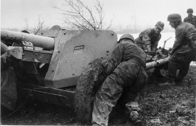 Preparing one of their defensive lines intended to slow the dogged Allied advance into northern Italy, fatigued German airborne troops, or Fallschirmjäger, manhandle an artillery piece into position. This photo was taken in February 1945.