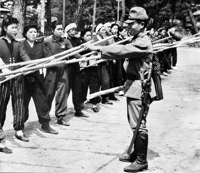 A Japanese Army officer instructs a group of housewives in the use of bamboo spears. Japan was depending on a huge home defense army to keep invaders out of the home islands.