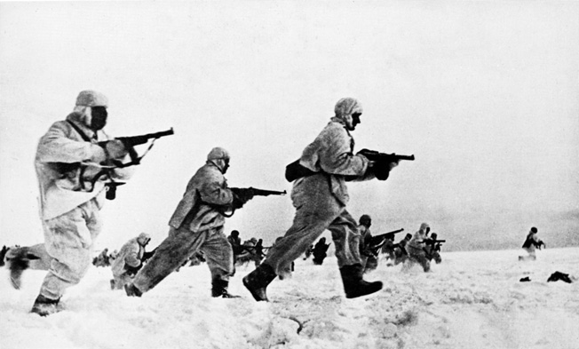 Soviet troops clad in white camouflage suits and carrying automatic weapons charge toward German positions north of Moscow. The resurgent Red Army held the line at Moscow, but continued to suffer serious reverses in 1942.
