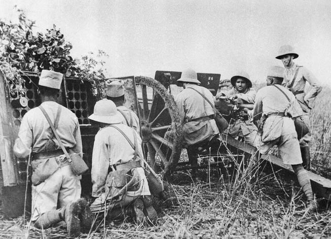 Vichy French forces on Madagascar included both French soldiers and colonial troops from Senegal and other locations. In this photo, colonial soldiers fire a canon under the watchful eye of a French officer in 1942.