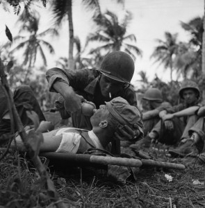 A Navy corpsman gives a drink of water to a wounded Marine on the island of Guam in the Pacific. In addition to the thousands of casualties treated by the U.S. Army medical personnel, the U.S. Navy also trained many for the war effort.