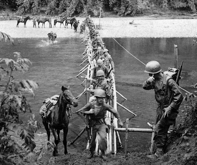 Men and mules from the 2nd Battalion use a sturdy bamboo bridge built by Kachin tribesmen to cross the Tanai River near the village of Ning Awng, March 18, 1944. 