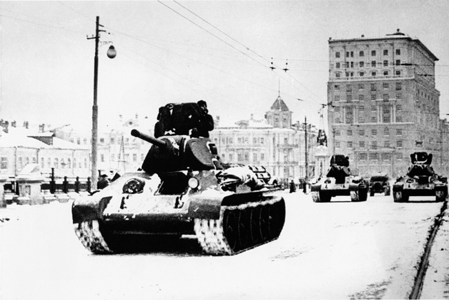 With the front line no more than 20 miles away, newly arrived Soviet tanks roll through the streets of Moscow to bolster the city's defenses.