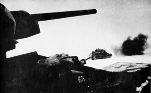Advancing during their successful effort to recapture Klin, Soviet tanks with infantrymen aboard dodge German artillery shells. Numerous German units narrowly escaped annihilation during the fighting near Moscow.