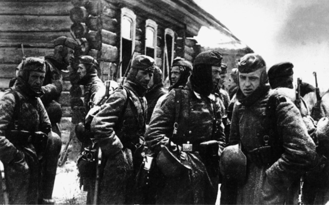 The lack of winter clothing, as seen in this photograph of German troops awaiting orders outside a command post near Moscow in November 1941, hampered the efforts of the Wehrmacht to capture the Soviet capital city.