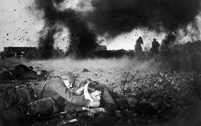 Bursting Soviet artillery shells send shrapnel, earth, and debris raining down on German soldiers near Moscow. The intensity of this bombardment is apparent on the faces of the frightened German soldiers in the foreground.