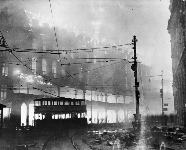 The ruins of a London street continue to burn after a December 14, 1941 raid.