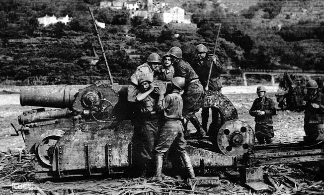 During fighting in the Western Alps in June 1940, Italian gun crewmen load a howitzer in preparation for an artillery barrage against opposing French forces.