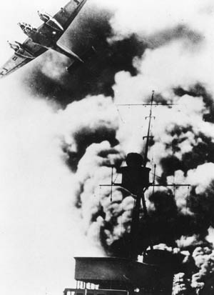 A German Me-110 fighter streaks over a smoking German destroyer during the intense fighting of April 5, 1940.
