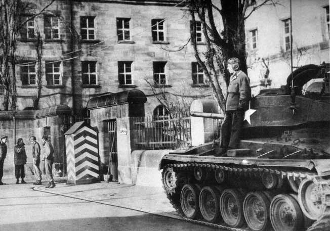 A U.S. tank and a number of infantrymen guard the entrance to the Palace of Justice at Nuremberg. Concerns over disruptions of the trials of accused Nazi war criminals prompted tight security during the proceedings. 