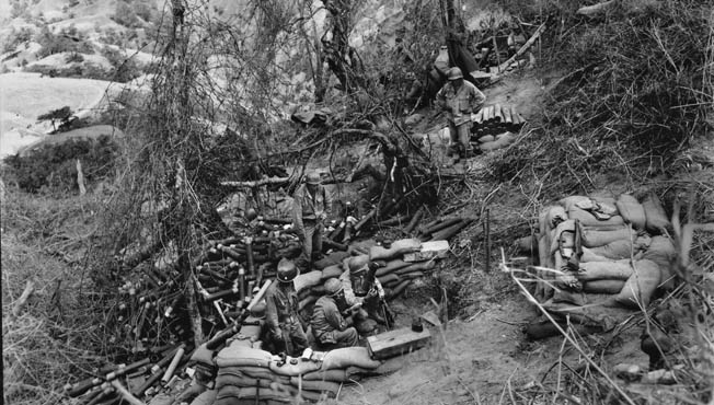 An American mortar crew services its weapon on a Luzon hillside. This photograph was taken during an attack on the headquarters of Japanese commanding general Tomoyuki Yamashita. These men withstood three days and nights of enemy counterattacks.