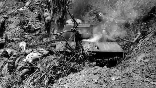 A Japanese Type 95 Ha-Go light tank smolders after soldiers of the 37th Infantry Division have destroyed the threat near the village of Bone, Luzon. At the end of three weeks of fighting the Japanese 2nd Tank Division had lost most of its tanks.