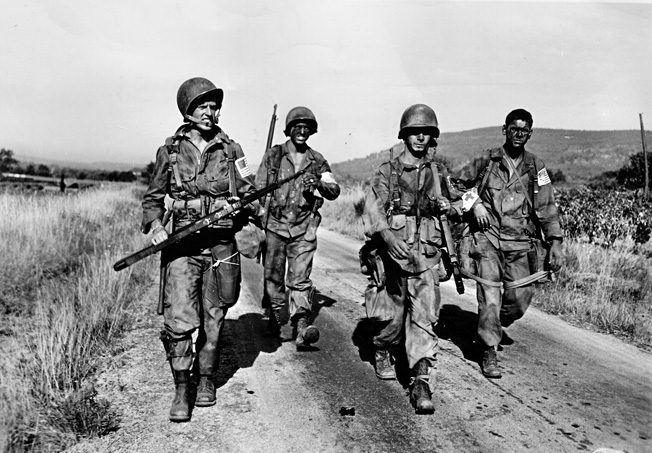 Near the French town of Le Muy, American paratroopers of the 509th Parachute Infantry Battalion hurry down Route D7 on the morning of August 15, 1944.