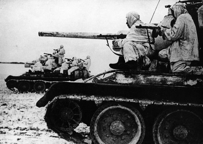 Assuming the offensive, Red Army soldiers exploit a breakthrough in the German lines as they ride aboard Soviet T-34 tanks.