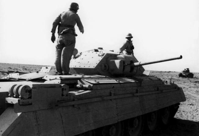 Captured with the fall of Bir Hacheim in North Africa, a Crusader tank is inspected by German troops. Practically in tact, this vehicle was also taken with plenty of ammunition to turn against its original owner.