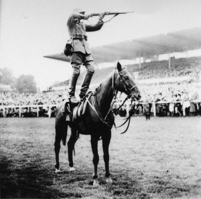 A German Army cavalryman fires his Mauser 98 bolt action rifle standing atop a horse in a prewar demonstration.