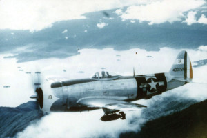 A Thunderbolt aircraft of the Mexican 201st Fighter Squadron flies in formation above Clark Field in the Philippine Islands. Note the bomb attached to the hard point beneath the fuselage.