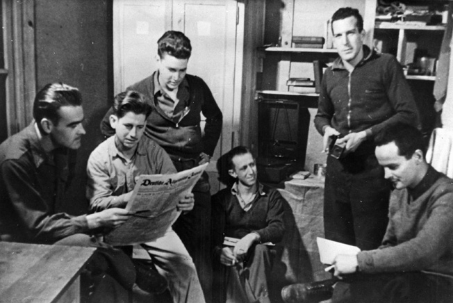 In this staged photograph, captured American airmen peruse a German newspaper in Stalag Luft III. In reality, the conditions in German POW camps were harsh at best. The situation deteriorated rapidly as the Allied armies advanced into Germany.