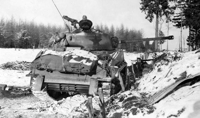 It's star insignia painted dark, an American M4 Sherman tank takes up a position in the snow near the town of Bastogne, Belgium, during the Battle of the Bulge. Note the high-velocity 75mm cannon that replaced the less potent main weapon on the earlier Sherman models.