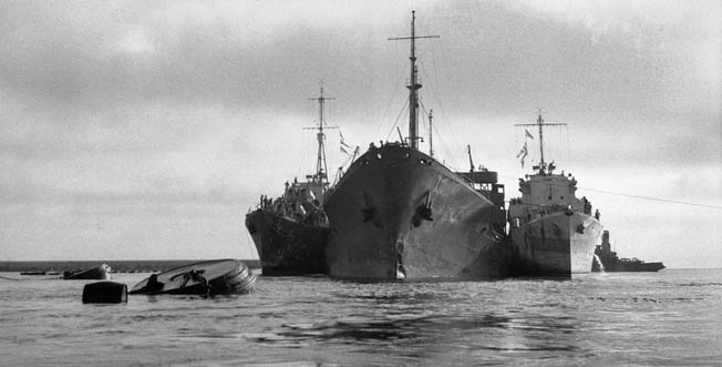 American oil tanker Ohio is supported by two Royal Navy destroyers as it approaches Malta following epic voyage through the Mediterranean, August 1942. Having surviving torpedos, aerial bombardment, and a fire, the Ohio, manned by a British crew, was called “the ship that wouldn’t die.”