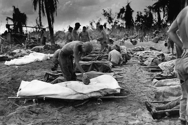 Dead Americans on Peleliu are wrapped for burial; more than 2,300 were killed, compared to 10,000 Japanese defenders. It was casualties like these that convinced U.S. leaders that without Japan’s unconditional surrender, defeating the nation would be terribly costly for both sides.