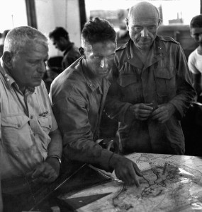 Major General Roy Geiger, left, and Major General William Rupertus, right, study a map in a captured Japanese building on Peleliu. 