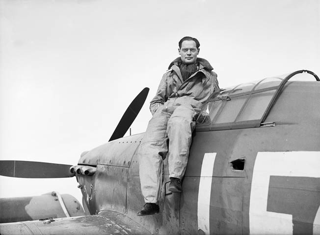 Squadron Commander Douglas Bader sits on the edge of the cockpit of his Hawker Hurricane fighter. 