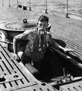 030808-N-0000X-001 Navy File Photo -- USS V-5 (SC 1) crewman A. L. Rosenkotter exits the submarine’s escape hatch wearing the "Momsen Lung" emergency escape breathing device during the submarine’s sea trials in July, 1930. The emergency breathing device was named for its inventor, U.S. Navy submarine rescue pioneer Cdr. Charles "Swede" Momsen. The submarine V-5 was later renamed USS Narwhal (SS 167). U.S. Navy photo. (RELEASED)