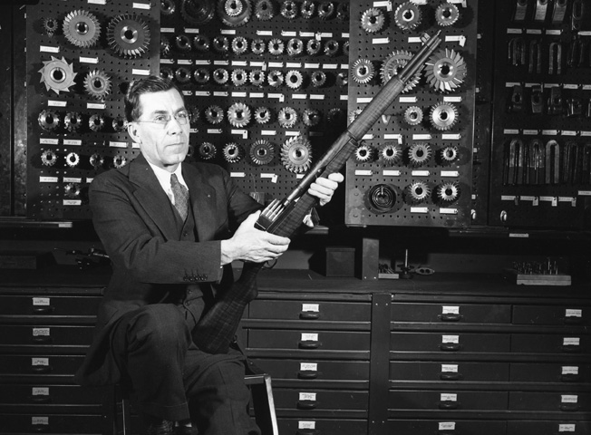 Canadian inventor John C. Garand holds his famous M-1 rifle.