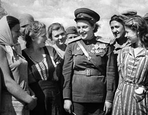 Soviet hero Pavlichenko meets factory workers near the city of Odessa. Pavlichenko became a national hero as stories of her exploits were published.