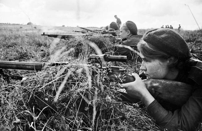 Taking positions in support of the Third Shock Army on the Kalinin Front in 1943, Soviet sniper Lyuba Makarova and other female snipers peer through their rifle scopes before seeking concealment to hit targets of opportunity.