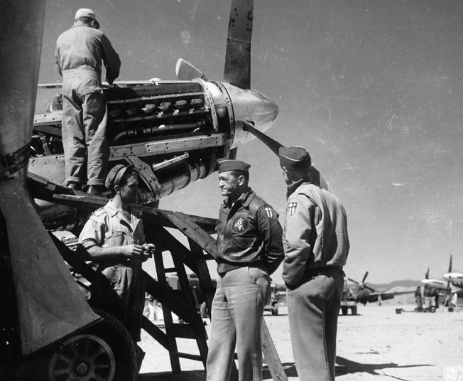 Later in his career, General Claire Chennault commanded the U.S. Fourteenth Air Force. Here, he is shown talking with a sergeant who is working to repair a fighter plane engine at an airstrip somewhere in China.