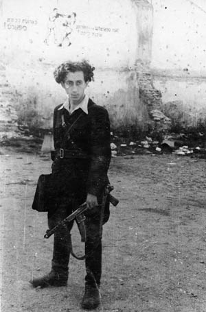 Partisan Abba Kovner stands with weapon in hand after the city of Vilnius has been occupied by the Soviet Red Army.