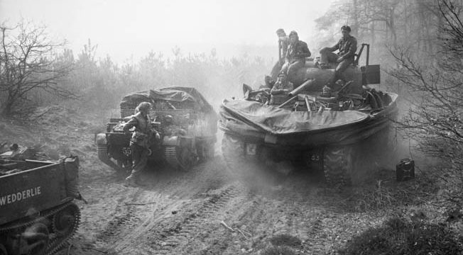After crossing the Rhine, a Sherman Duplex Drive amphibious tank (right) provides a lift to men of the 6th Kings Own Scottish Borderers, 15th Scottish Division, moving to link up with the 507th PIR.