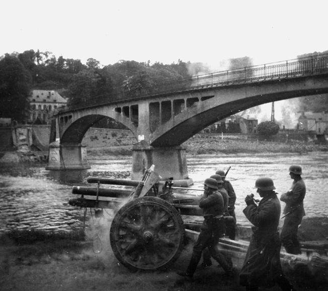 The 7th Panzer Division artillery opens up on French positions near a destroyed bridge.