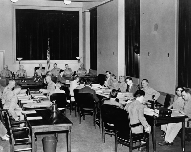 At the Department of Justice in Washington, D.C., Room 5235 was converted into a courtroom for the trial of the Operation Pastorius conspirators. The generals of the military commission that presided are in the rear, while Attorney General Francis Biddle and the Prosecution staff are on the right and defense attorneys are on the left. Behind them are the defendants.