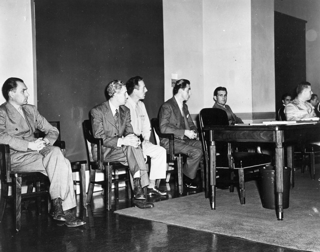 Four of the German saboteurs, captured and on trial for their lives, listen attentively during the proceedings. Pictured from left to right are Werner Thiel, Richard Quirin, an unidentified U.S. sldier, Hermann Neubauer, and Edward Kerling.