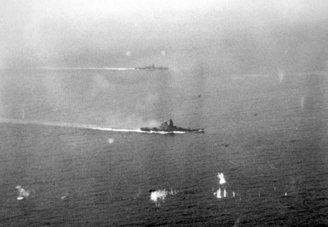 The Japanese super battleship Yamato, with 18.1-inch main guns, stirs a wake as it maneuvers during the battle off Samar. A Japanese heavy cruiser is visible of the Yamato’s port quarter.