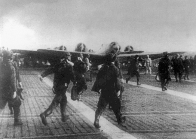 Briefed on their objectives for Pearl Harbor, Japanese pilots rush across the deck of an aircraft carrier on the morning of December 7, 1941.