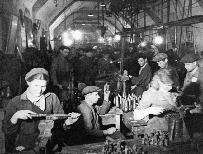Toiling away in an underground shelter lit by bare lightbulbs, citizens of Sevastopol work overtime to aid the defense effort.