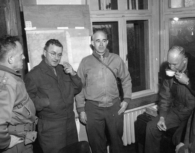 Shown conferring with Supreme Allied Commander Dwight D. Eisenhower (far right) are (left to right) Maj. Gen. John Leonard, commander of the 9th Armored Division, Maj. Gen. Troy Middleton, commander of the VIII Corps, and Lt. Gen. Omar Bradley, commander of the 12th Army Group.