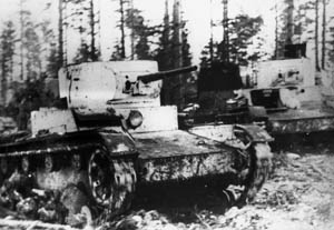 Soviet tanks and infantry advance along a narrow road in Finland. The dense forest growth and narrow roadways minimized the effectiveness of Red Army tanks during the Winter War. 
