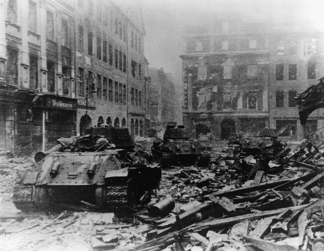 Soviet T-34 tanks rumble through the rubble-strewn streets of Berlin in May 1945.