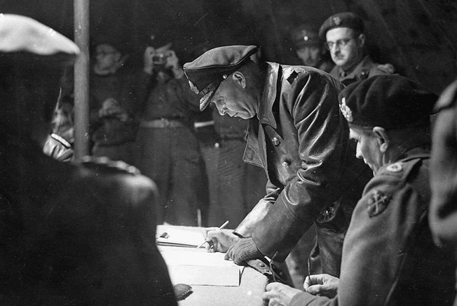 Colonel Johannes Blaskowitz signs formal surrender papers. 