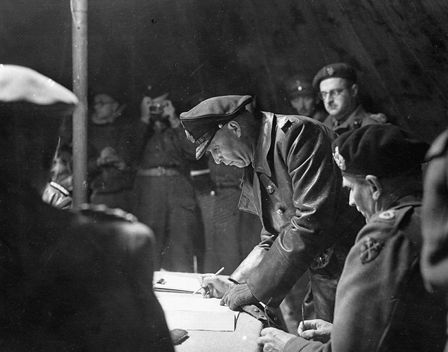 Colonel Johannes Blaskowitz signs formal surrender papers.