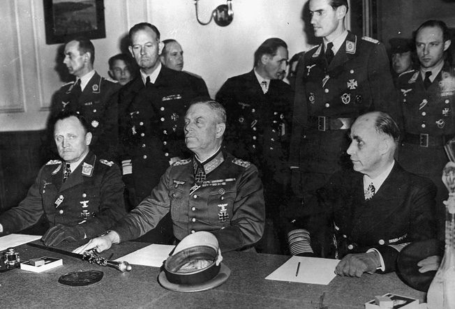 Col. Gen. P.F. Stampf and Field Marshal Wilhelm Keitel sign surrender papers at Russian headquarters in Berlin.