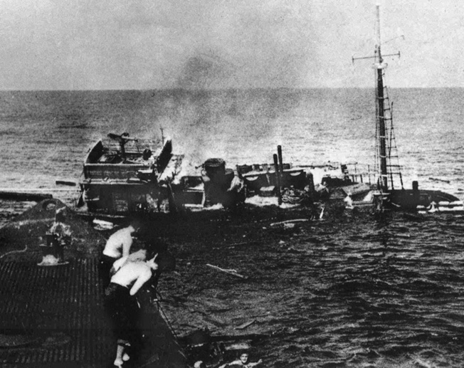 As the Chiyo Maru sinks beneath them, Japanese sailors are helped aboard the USS Tambor. U.S. submariners were often able to pick up survivors until reports of possible enemy activity forced them to withdraw.