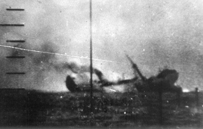 Its back broken by a torpedo from the USS Tambor, a Japanese freighter begins its plunge to the bottom of the Pacific. Note the rising bow and stern sections of the large vessel as smoke billows from its funnel. 